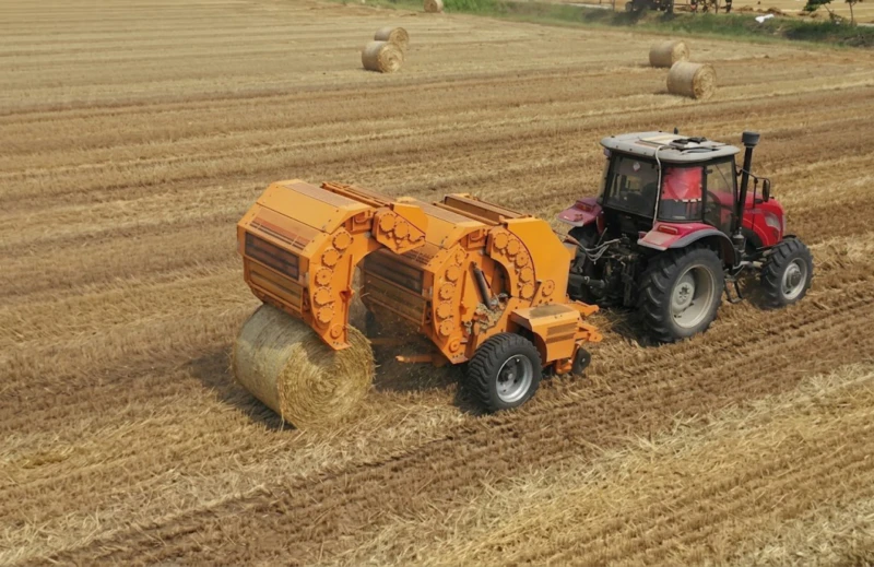 Round baler binding system showing net wrap and twine application mechanisms